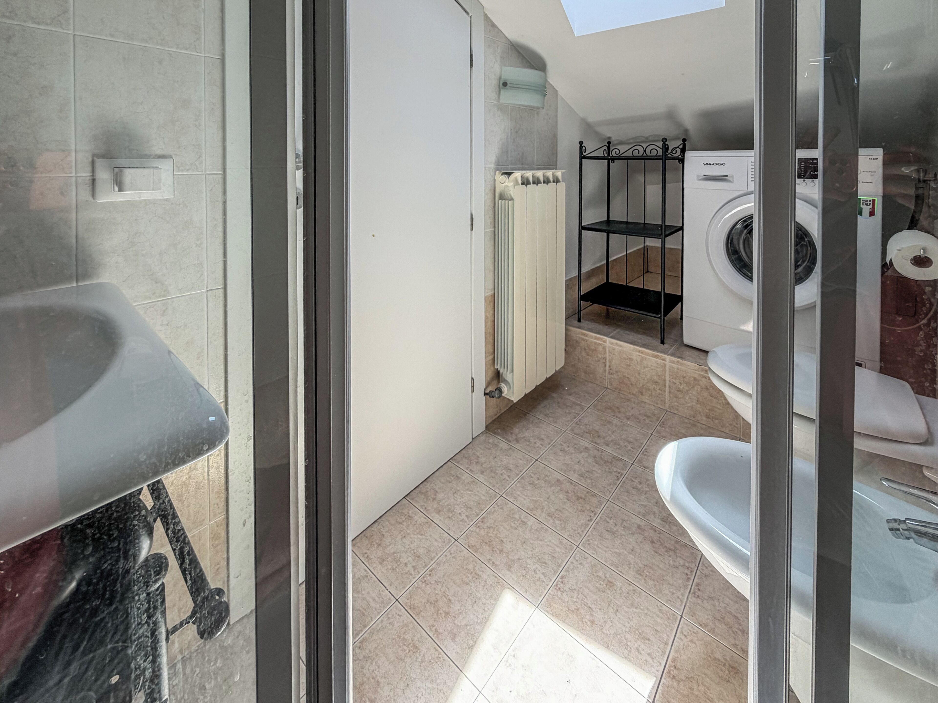 Ein modernes Badezimmer mit Dusche, Toilette und Waschmaschine.