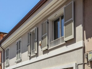 A building facade with multiple windows, shutters, and a visible air conditioning unit. - Casa Nuvola (Senigallia)