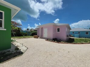 Ein Wohngebiet mit einem rosa Haus, einem blauen Haus und einem grünen Haus.