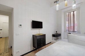 A bedroom with a bed, a dresser, a television, and a window with curtains. - Ellie Luxury Apartment with Balcony, Wi-Fi, and Air Conditioning (Rome)