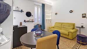 Un saló modern amb una taula rodona, un sofà i una zona de menjador.