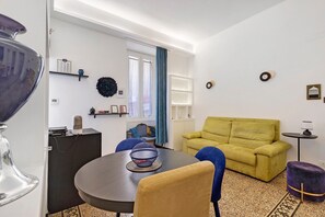 Ein modernes Wohnzimmer mit einem runden Tisch, einer Couch und einem Essbereich.