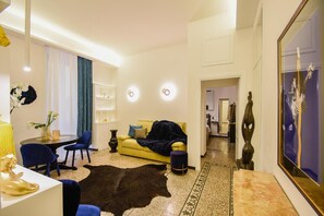 Ein modernes Wohnzimmer mit einer Couch, Sesseln, einem Teppich und einem Essbereich mit Tisch und Stühlen.