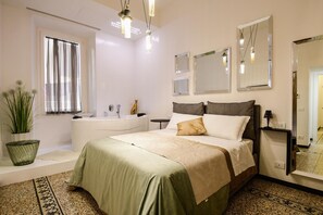 Ein Hotelzimmer mit Bett, einem Badezimmer mit Badewanne und einem großen Spiegel.