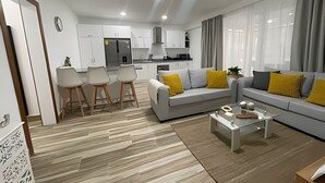 Una sala de estar moderna con sofá, mesa de centro y comedor.