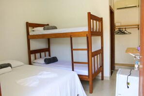 A bunk bed room with a single bed, a wooden headboard, and a small desk with a chair.