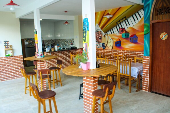 Un comedor con paredes de ladrillo, mesas y sillas de madera.