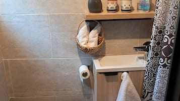 Chuveiro, toalhas de banho, papel higiênico