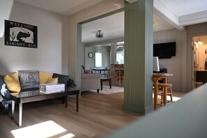 Ein Wohnzimmer mit einer Couch, einem Couchtisch und einem Willkommensschild.