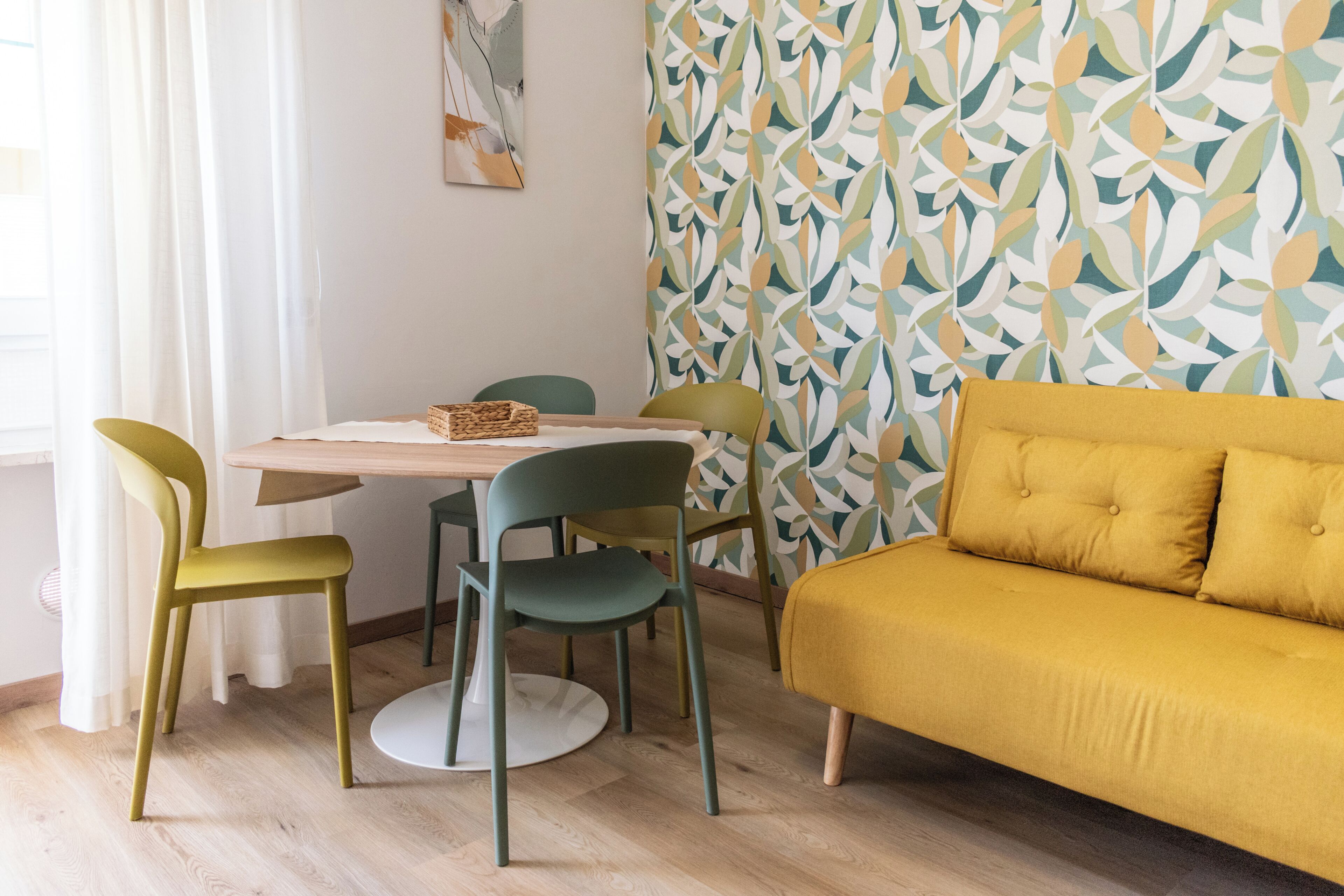 A dining area with a table, chairs, and a sofa.