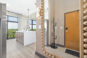 Eine moderne Küche mit einer großen Kochinsel, Blick ins Freie und einer Tür mit besonderem Design.