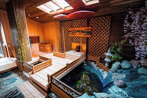 A traditional Japanese-style room with tatami flooring, a wooden deck, a koi pond, and a shoji screen. - Exclusive Whole-House Ryokan in Sapporo | Features a Japanese Garden, Open-Air Bath, and Sauna / Accommodates up to 16 Guests: 10-minute walk from Subway 27-jo Station (札幌市)