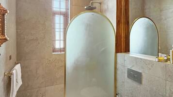 Ein modernes Badezimmer mit Duschkabine aus Glas, Toilette, Waschbecken und einem Fenster.