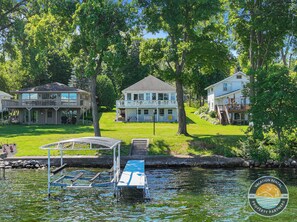 A lakeside property with a dock, a covered boat launch, and a house with a balcony. - Lake Delavan Lakefront Home, Pier, Sleeps 6 (Delavan)