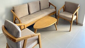 A modern living room with a sofa, two armchairs, and a coffee table.