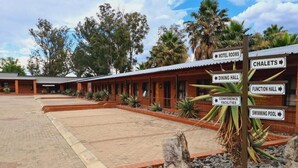 Ein Hotel mit Backsteinfassade, mehreren Zimmern, einer Speisesaal, einem Veranstaltungsraum, Konferenzeinrichtungen und einem Schwimmbad.