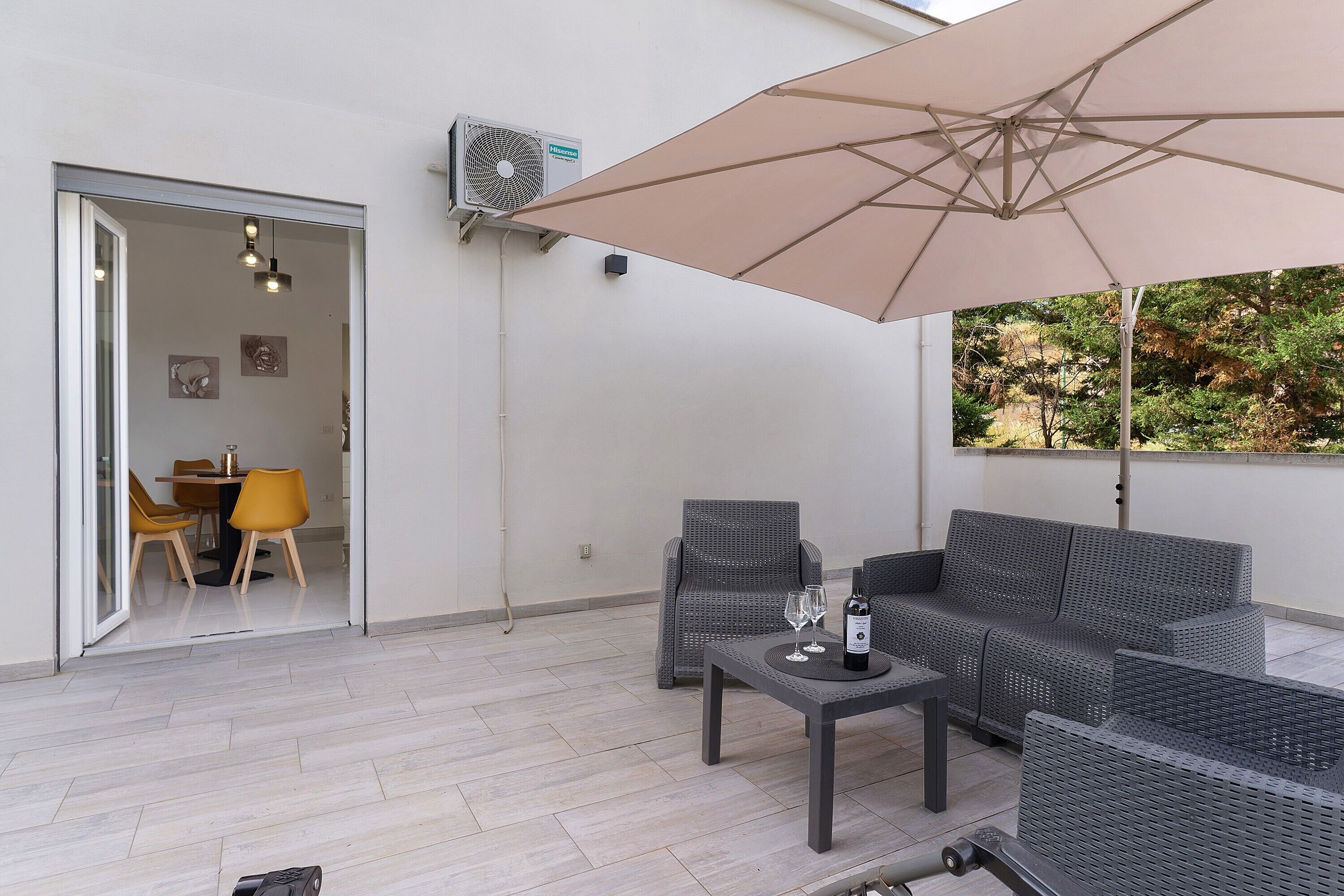 An outdoor seating area with a table, chairs, and an umbrella.
