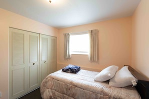 A bedroom with a bed, a window with curtains, and a wardrobe. - Comfortable 4-Bedroom Home in Mt Morris (Mount Morris)