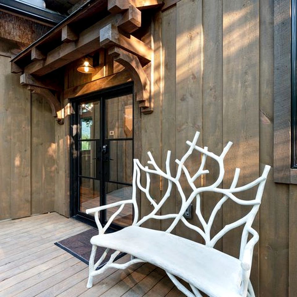 A wooden bench outside a building with a glass door.