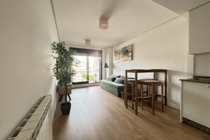 Ein modernes Apartment mit Küche, Essbereich und großem Fenster.