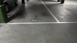 A parking garage with concrete floors, marked parking spaces, and green pillars. - Desconectaengalicia Mar de Silgar 2, 600 m from Silgar Beach (Pontevedra)
