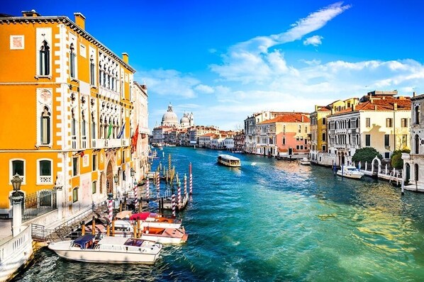A canal with boats docked, historic buildings, and a prominent dome in the background. - Refined Venice Lido Retreat with Terrace, Garden & Steps to the Beach (Lido)
