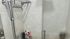 A bathroom with a toilet, bidet, and a glass shower enclosure. - Hanoi Homestay Minh Nhat (Hanoi)
