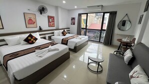 A hotel room with two beds, a sofa, a small table, and a balcony with a view. - Hanoi Homestay Minh Nhat (Hanoi)