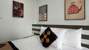 A hotel room with a bed, a pillow, a wall-mounted picture, and a wall socket. - Hanoi Homestay Minh Nhat (Hanoi)