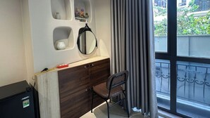 A room with a wooden dresser, a chair, a mirror, and a window with curtains. - Hanoi Homestay Minh Nhat (Hanoi)