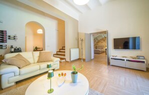Ein modernes Wohnzimmer mit einer Couch, einem Couchtisch und einem Fernseher.