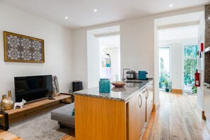 Une cuisine moderne dotée d’un îlot central, de meubles en bois et d’un four encastré.