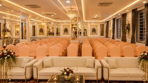A formal event space with rows of chairs, a central aisle, and a stage.