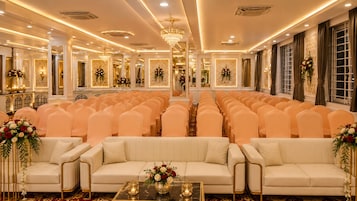 Un espacio para eventos formales, con filas de sillas, un pasillo central y un escenario.