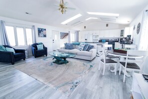 A spacious living area with a sofa, armchairs, and a coffee table. - Welcome to The Coastal Crown, your ultimate luxury beach getaway! 👑<br>✨ Top-Floor Penthouse<br>🏖️ Steps to the Beach<br>🌊 Balcony Ocean Views<br>🛁 Master Suite Jacuzzi<br>📺 85" TV & Skylights (North Myrtle Beach)