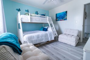 A bunk bed room with a ladder, a single bed, and a chair. - Welcome to The Coastal Crown, your ultimate luxury beach getaway! 👑<br>✨ Top-Floor Penthouse<br>🏖️ Steps to the Beach<br>🌊 Balcony Ocean Views<br>🛁 Master Suite Jacuzzi<br>📺 85" TV & Skylights (North Myrtle Beach)
