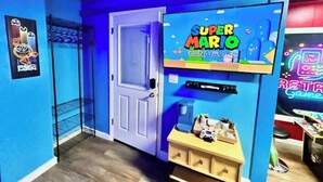 Ett rum med en blå vägg, ett ljudsystem med Super Mario-tema, en dörr och en hylla med diverse föremål.