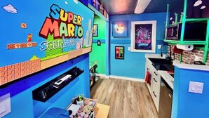 Ett rum med Super Mario-tema, inklusive en väggmålning och en hylla med spelrelaterade föremål.