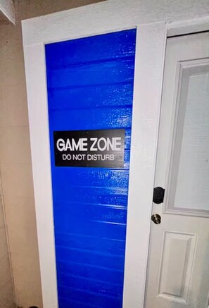 A door with a blue door frame and a sign that reads 'GAME ZONE DO NOT DISTURB.' - GameZone PacMan Arcade, WiFi, Free Parking (Sparks)