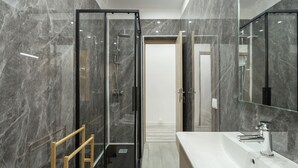 A modern bathroom with a glass-enclosed shower, a large mirror, and a white sink. - Lisbon Modern Suites IV by Homing (Lisbon)