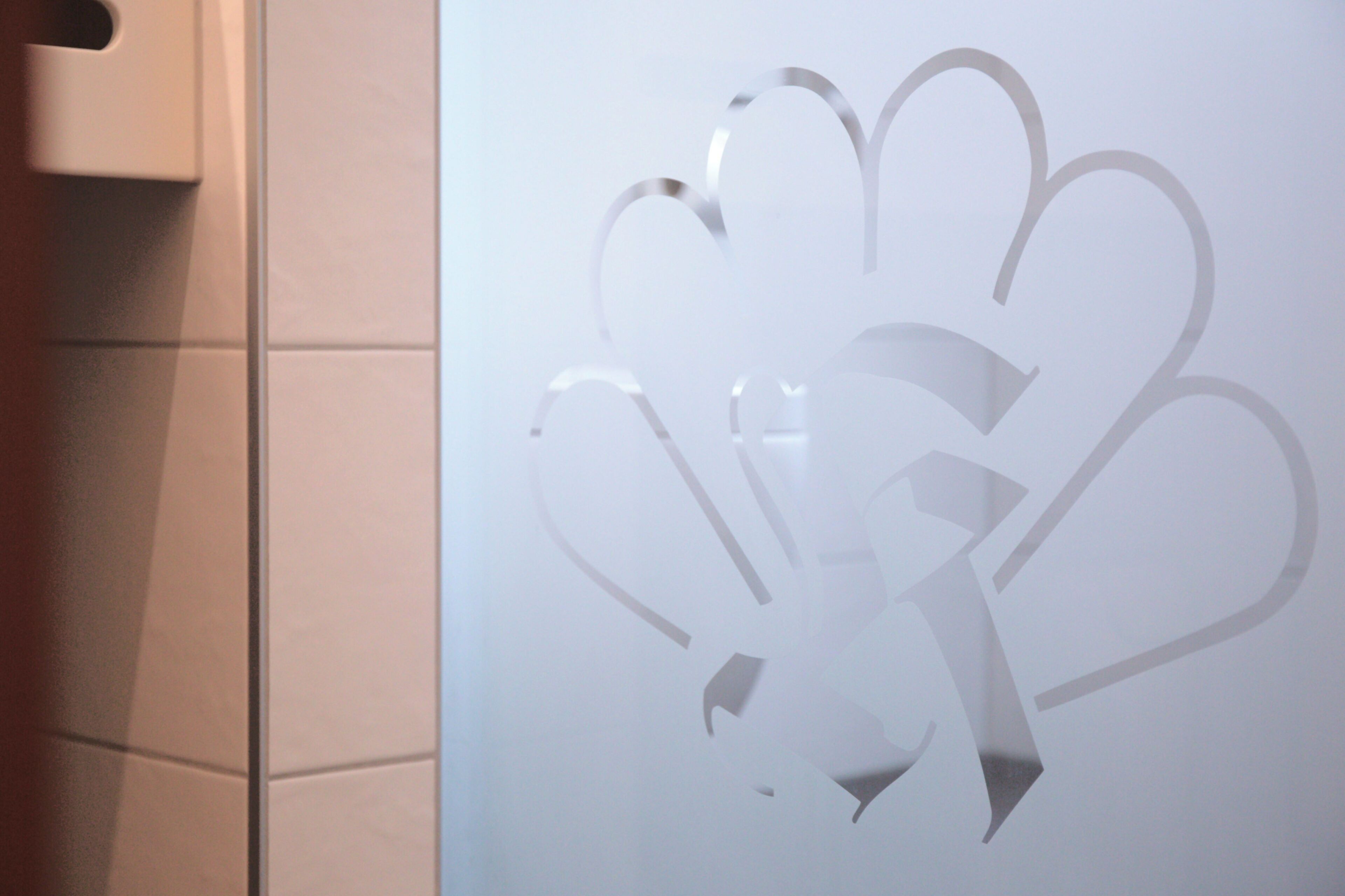 Una pared con un logotipo recortado de diseño floral.