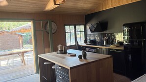 Eine Küche mit Holzbalken, einem Einbauofen und einem Spülbecken.