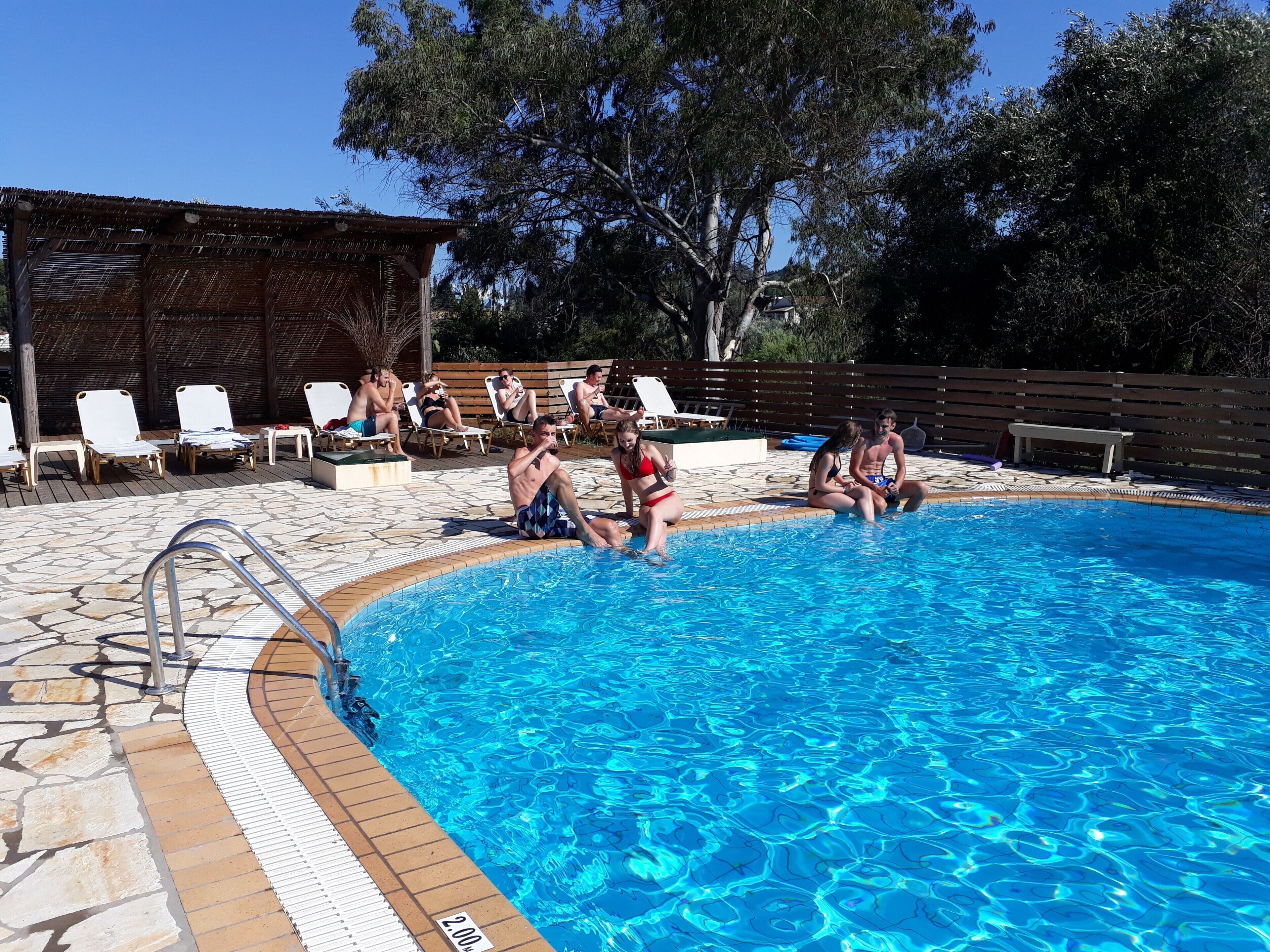 Ein Schwimmbecken mit Liegestühlen und einer Holzterrasse.