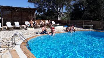 Ein Schwimmbecken mit Liegestühlen und einer Holzterrasse.