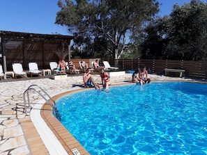 A swimming pool with lounge chairs and a wooden deck. - Value Double Lower – Room 12 (Kontokali)