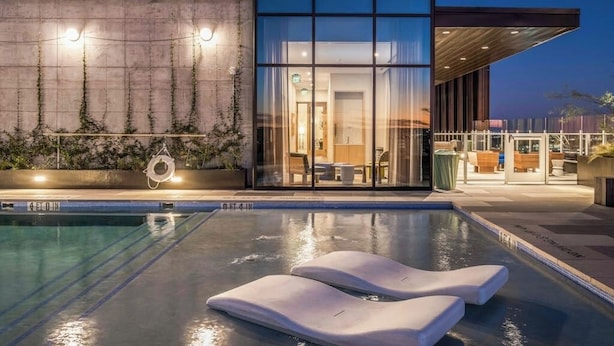 Ein modernes Hotel mit Schwimmbad, einer Lounge und Blick ins Innere des Gebäudes.