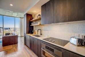 Eine moderne Küche mit dunklen Holzschränken, einem großen Fenster und Blick auf die Stadt.