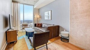 Ein modernes Wohnzimmer mit einer Couch, einem Sessel, einem Couchtisch und einem Fernseher.