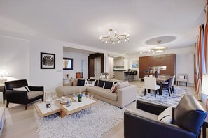 A modern living room with a sofa, armchairs, a coffee table, and a dining area with chairs and a table. - TOP OF THE RANGE- LUXURY DESIGNER APARTMENT AVE RAYMOND POINACARE (Paris)
