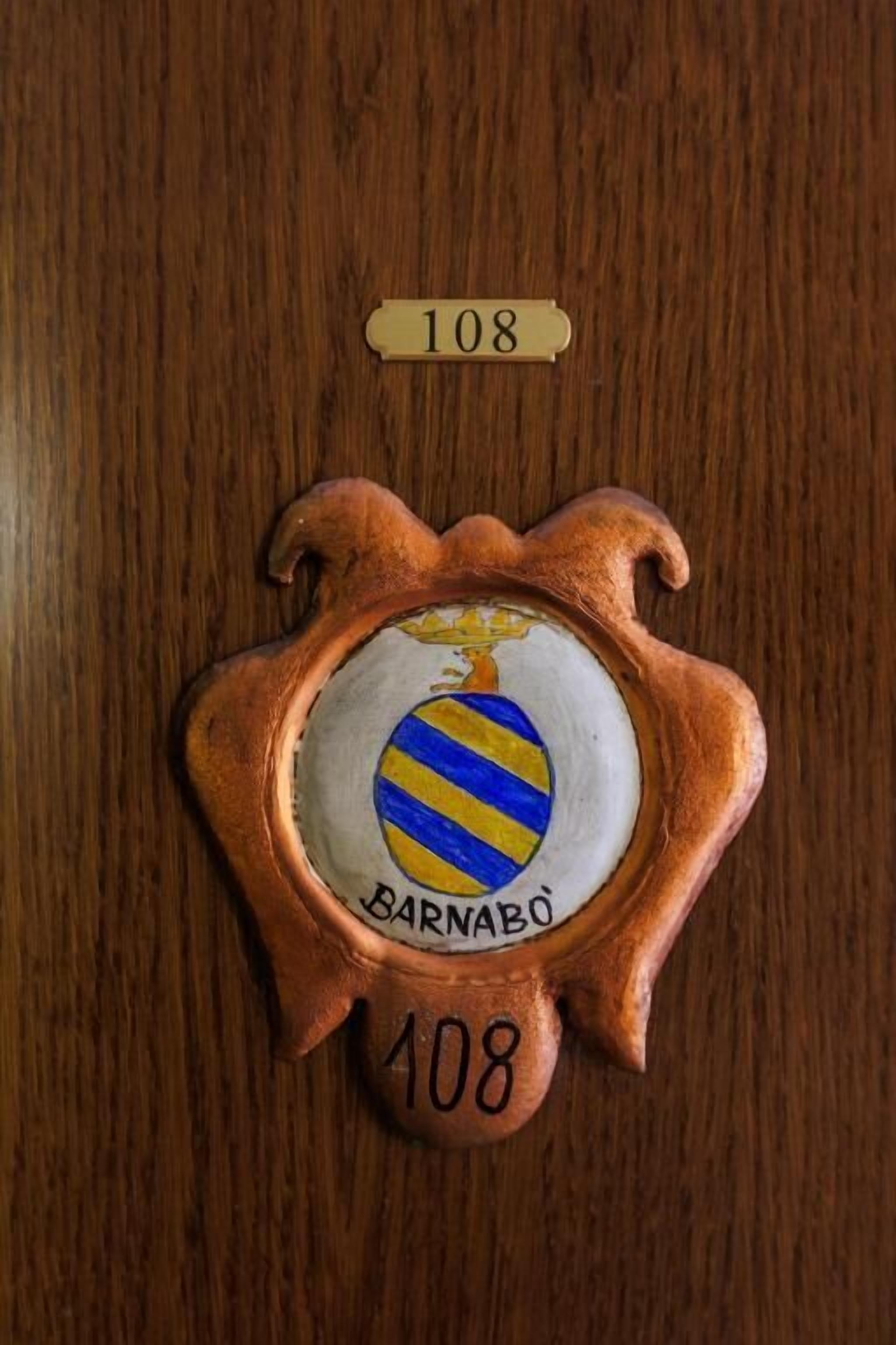 Une porte en bois ornée d’une plaque en laiton et d’une plaque nominative.